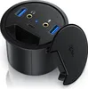 A black circular desk grommet with multiple ports, including USB-A, USB-C, and audio jacks, with its lid open. Podgląd zdjęcia produktu