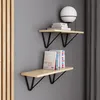 Two modern shelves mounted on a gray wall, with books and a lamp on them. Produktbild-Vorschau