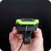 A hand holds a bicycle light with a USB charging port. Podgląd zdjęcia produktu