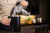 A person pouring water from a filter pitcher into a black electric kettle. Produktbild-Vorschau
