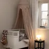 A baby's crib with a canopy, blanket, and stuffed animal. Produktbild-Vorschau