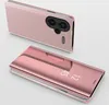 Two pink smartphone cases are displayed against a light gray background. One case is shown from the back, revealing the camera module, and the other is shown from the front with the flip cover closed. Produktbild-Vorschau