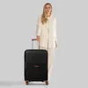 A woman stands next to a black trolley suitcase. Podgląd zdjęcia produktu