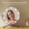 A woman is reflected in a makeup mirror with LED lights, holding a cosmetic product. Náhľad obrázku produktu