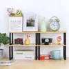 A two-tiered shelf unit with various decorative items and books on display. Produktbild-Vorschau