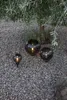 Three decorative globe lights are placed on a gravel ground under a tree. Produktbild-Vorschau