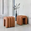 Two orange upholstered stools are placed in a modern hallway with concrete walls. Anteprima dell’immagine prodotto