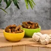 Two bowls of dried chicken necks on a burlap cloth, with decorative rope balls in the foreground and greenery in the background. Produktbild-Vorschau