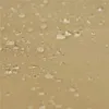 A close-up view of a tan fabric surface with water droplets on it, showing the texture of the material. Produktbild-Vorschau