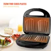A sandwich maker is open, showing its heating plates, with food items and a drink in the background. Voir les images du produit