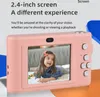 A pink digital camera with a picture of a child on its screen, set against a light gray and orange background with text overlays. Náhled obrázku produktu