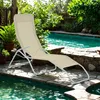 A beige lounge chair is placed on a stone patio next to a swimming pool. Produktbild-Vorschau
