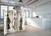 A room divider with vintage fashion illustrations is placed in a modern kitchen and living area. Produktbild-Vorschau