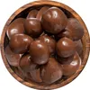 A close-up, top-down view of chocolate-covered strawberries in a wooden bowl. Produktbild-Vorschau