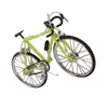 A miniature green bicycle model with black handlebars and a black water bottle holder. Produktbild-Vorschau