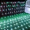 A net of white LED lights is draped over a wooden fence and onto green grass, decorated with some Christmas ornaments. Produktbild-Vorschau