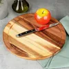 A wooden cutting board with an apple and a knife on it. Produktbild-Vorschau