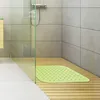 A shower stall with a wooden floor and a green bath mat. Produktbild-Vorschau