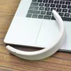 A white headband rests on a laptop keyboard and trackpad, with a wooden surface visible below. Voir les images du produit