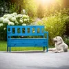 A blue wooden garden bench with a dog lying next to it in a sunny garden. Anteprima dell’immagine prodotto