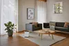 A modern living room with a sofa, armchair, coffee table, and an air purifier. Náhľad obrázku produktu