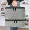 A person is holding a two-tiered gray cosmetic bag. Produktbild-Vorschau