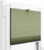 A close-up view of a green pleated blind installed in a white window frame. Produktbild-Vorschau