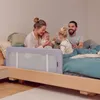 A family with two young children is sitting on a bed, with a bed rail installed. Anteprima dell’immagine prodotto