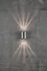 A silver cylindrical wall light fixture mounted on a textured gray concrete wall, casting upward and downward beams of light. Anteprima dell’immagine prodotto
