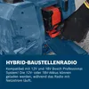 A hand in a black glove is inserting a battery into a blue construction radio. Produktbild-Vorschau