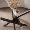 Close-up of a black coffee table with a glass top, decorated with dried flowers in a white vase, on a wooden floor. Produktbild-Vorschau