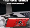 A red phone case with a ring holder is shown in a close-up shot, with a blurred background of a laptop. Produktbild-Vorschau