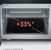 Interior view of a microwave oven showing a black glass base with an orange graphic indicating a 33% increase in capacity. Podgląd zdjęcia produktu