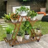 A wooden plant stand with multiple plants on it, placed outdoors on a wooden deck. Produktbild-Vorschau