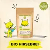 A cartoon lynx is shown eating from a bowl next to a bag of Helpa BIO Hirsebrei. Produktbild-Vorschau