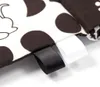 Close-up of fabric tags on a black and white polka dot patterned item. Produktbild-Vorschau