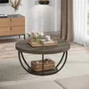 A round coffee table with a lower shelf is placed on a patterned rug in a living room setting. Produktbild-Vorschau