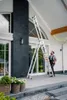 A man is using a multi-purpose ladder outside a modern house. Produktbild-Vorschau