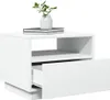 A white modern nightstand with one drawer partially open, placed on a white background. A stack of books and a small plant in a white vase sit on top. Voir les images du produit