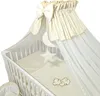 A baby crib with bedding and a canopy. Náhled obrázku produktu