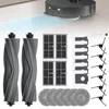 A collection of robot vacuum cleaner accessories, including brushes, filters, and mop pads, arranged on a light gray and white background. A portion of a robot vacuum cleaner is visible in the upper left corner. Voir les images du produit