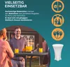 People interacting at an outdoor event with a table and drinks. Produktbild-Vorschau