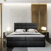 A modern bedroom with a large upholstered bed as the focal point. Produktbild-Vorschau