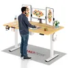 A man is standing at a height-adjustable desk with multiple monitors, a mat on the floor, and various desk accessories. Anteprima dell’immagine prodotto