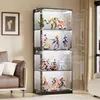 A modern glass display cabinet filled with various collectible figures, placed in a living room setting next to a sofa. Náhľad obrázku produktu