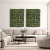 A living room scene with a sectional sofa, coffee table, and two large green leaf panels mounted on the wall. Anteprima dell’immagine prodotto