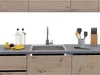 A modern kitchen counter with a sink, faucet, and various kitchen accessories. Náhled obrázku produktu