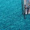 A close-up view of a fluffy, turquoise carpet. Anteprima dell’immagine prodotto