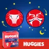 A product shot of Huggies Overnights diapers with instructional graphics and branding. Produktbild-Vorschau