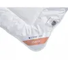 A close-up view of a white duvet with a label indicating the brand and product line. Podgląd zdjęcia produktu